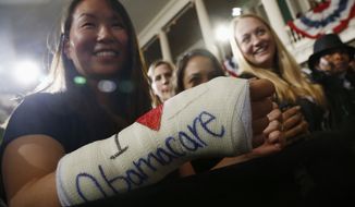 Cathey Park from Cambridge, Mass. shows the words &quot;I Love Obamacare&quot; on her cast for her broken wrist as she waits for President Barack Obama to speak at Boston&#39;s historic Faneuil Hall about the federal health care law, Wednesday, Oct. 30, 2013. Faneuil Hall is where former Massachusetts Gov. Mitt Romney, Obama&#39;s rival in the 2012 presidential election, signed the state&#39;s landmark health care law in 2006, with top Democrats standing by his side. (AP Photo/Charles Dharapak)