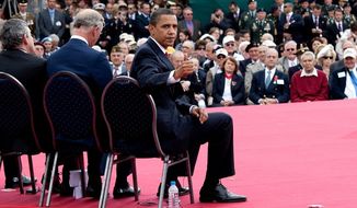 President Barack Obama gives a &#x27;thumbs-up&#x27; to a group of World War II veterans sitting behind him on stage following his speech at the 65th anniversary of the D-Day invasion in Normandy, France, June 6, 2009. (White House photo)