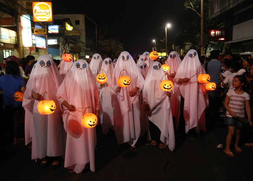 Filipinos wear ghost costumes as they join a Halloween Parade in Marikina city, east of Manila, Philippines on Wednesday, Oct. 30, 2013. Hundreds of residents and government employees joined the parade as the country prepares to observe All Saints Day on Nov. 1. (AP Photo/Aaron Favila)
