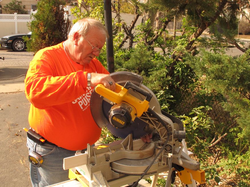 ** FILE ** Robert Gilbert, of Waverly, Ohio, cuts a piece of molding outside a Supestorm Sandy-damaged home in Freeport, N.Y., Tuesday, Oct. 29, 2013. Gilbert is a member of Samaritan's Purse, a Christian church group that travels the country assisting after disasters. (AP Photo/Frank Eltman)