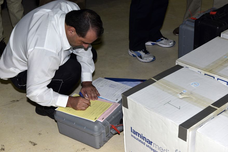 ** FILE ** In this photo released Saturday, Aug. 31, 2013, by the Organization for the Prohibition of Chemical Weapons, samples brought back by the U.N. chemical weapons inspection team are checked in upon their arrival at The Hague, Netherlands. An official at the global chemical weapons watchdog says Syria has completed destruction of critical equipment for producing chemical weapons and filling munitions with poison gas. (AP Photo/OPCW, Henry Arvidsson, File)
