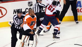 A linesman directs Philadelphia Flyers goalie Ray Emery, left, back towards the Flyers bench as Washington Capitals&#39; Steve Olesky and Flyers&#39; Vincent Lecavalier,  right, battle during a melee in the third period of an NHL hockey game Friday, Nov. 1, 2013, in Philadelphia. The Capital won 7-0. (AP Photo/Tom Mihalek)