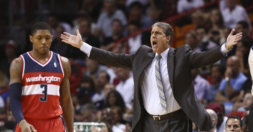 Washington Wizards coach Randy Wittman protests a penalty call against the team, after they fouled a Miami Heat player during the first half of an NBA basketball game in Miami, Sunday, Nov. 3, 2013. Bradley Beal walks past. (AP Photo/J Pat Carter)