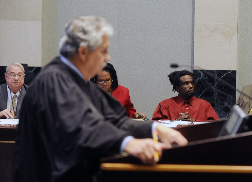 Jury selection for Dontae Morris, right, is underway in an Orlando, Fla. courtroom on Monday, Nov. 4, 2013, before Circuit Judge William Fuente. The judge in the foreground is asking prospective jurors questions about prior knowledge of this case. In back is Morris and members of his defense team. (AP Photo/Tampa Tribune, Jay Conner, Pool)