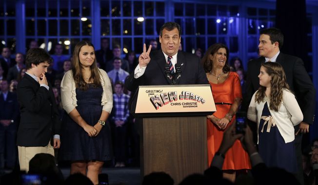 Republican New Jersey Gov. Chris Christie signals second term as he stands with his wife, Mary Pat Christie, center right, and their children, Andrew, back right, Bridget, front right, Patrick, left, and Sarah, second left, as they celebrate his election victory in Asbury Park, N.J., Tuesday, Nov. 5, 2013, after defeating Democratic challenger Barbara Buono. (AP Photo/Mel Evans)