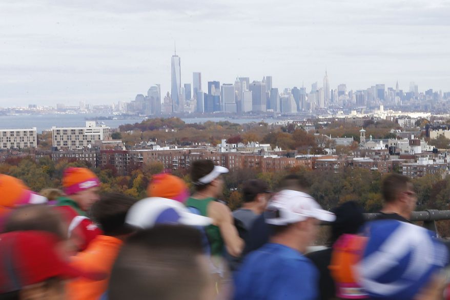 The Lower Manhattan skyline can be seen in the distance as runners cross the Verrazano-Narrows Bridge at the start of the New York City Marathon on Sunday, Nov. 3, 2013, in New York. (AP Photo/Jason DeCrow)