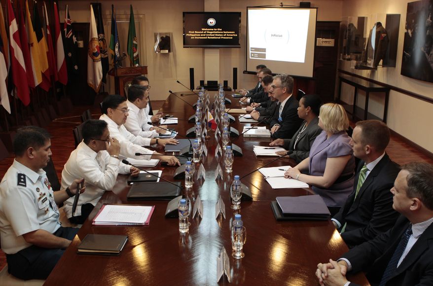 FILE - In this Aug. 14 file photo, Philippine chief government negotiator Carlos Sorreta, 3rd from left, starts meetings with US Department of State Ambassador Eric John, 5th from right, at the Department of National Defense headquarters in suburban Quezon city, north of Manila, Philippines. The Philippine defense chief said Tuesday Nov. 5, 2013 that disagreements between U.S. and Filipino negotiators are prolonging talks on an accord allowing an increase in American military presence in the country. (AP Photo/Aaron Favila, File)