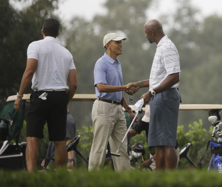 President Barack Obama, center, shakes hands with former NBA basketball player Alonzo Mourning, right, at Grande Oaks golf club, Saturday, Nov. 9, 2013 in Ft. Lauderdale, Fla. Obama traveled to the Miami area yesterday for a series of private Democratic fundraisers and a golf outing today. (AP Photo/Pablo Martinez Monsivais)