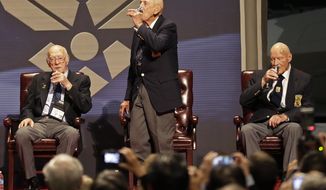 Richard Cole (center) proposes a toast with two other surviving members of the 1942 Tokyo raid led by Lt. Col. Jimmy Doolittle — Edward Saylor (left) and David Thatcher — on Saturday, Nov. 9, 2013, at the National Museum of the U.S. Air Force at Wright-Patterson Air Force Base in Dayton, Ohio. The fourth surviving member, Robert Hite, was unable to travel to the ceremonies. (AP Photo/Al Behrman)