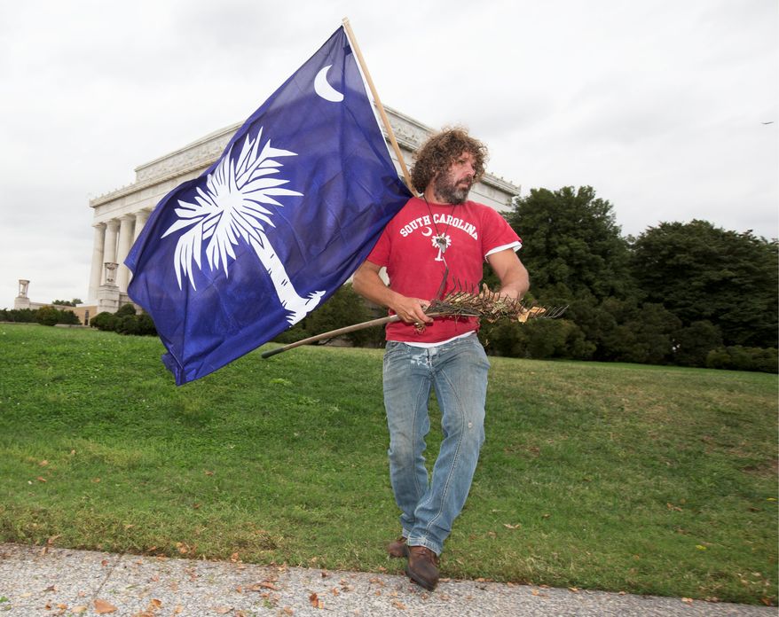 Chris Cox picks up dried leaves he raked near the Lincoln Memorial in October during the partial federal government shutdown. He took it upon himself to spruce up the grounds that were being neglected. He'll return Wednesday to receive a thank you. (ASSOCIATED PRESS)