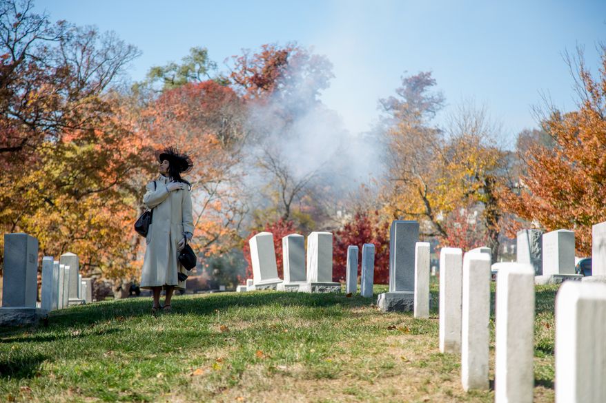 Evangelist Mary Clement, of Silver Springs, MD., holds her hand over her heart as a 21 gun salute is performed while the President's vehicle drives down the road leading up to the Tomb of the Unknown Solider during a Veteran's Day ceremony, in Arlington, VA., Monday, November 11, 2013.(Andrew S. Geraci/The Washington Times)