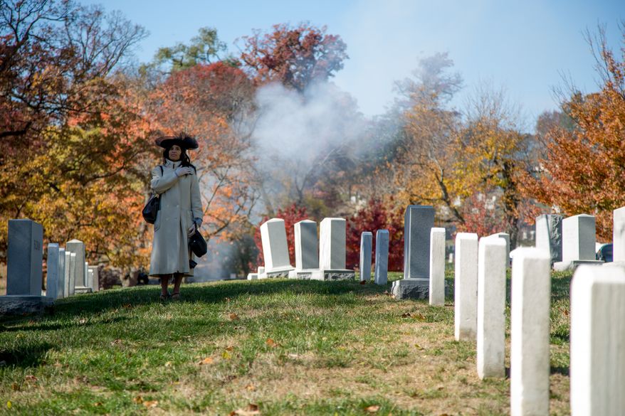 Evangelist Mary Clement, of Silver Springs, MD., holds her hand over her heart as a 21 gun salute is performed while the President's vehicle drives down the road leading up to the Tomb of the Unknown Solider during a Veteran's Day ceremony, in Arlington, VA., Monday, November 11, 2013.(Andrew S. Geraci/The Washington Times)