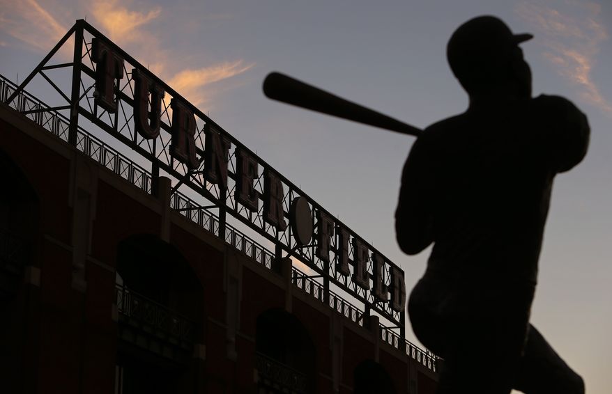 The sun sets over Turner Field and a statue of Hank Aaron on Monday, Nov. 11, 2013, the day the Braves announced that they would be moving to Cobb County. (AP Photo/The Atlanta Journal-Constitution, Ben Gray)