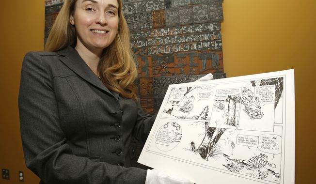 Juli Slemmons holds a &quot;Calvin and Hobbes&quot; comic by cartoonist Bill Watterson at the Billy Ireland Cartoon Library and Museum on the Ohio State University campus in Columbus, Ohio. (AP Photo)