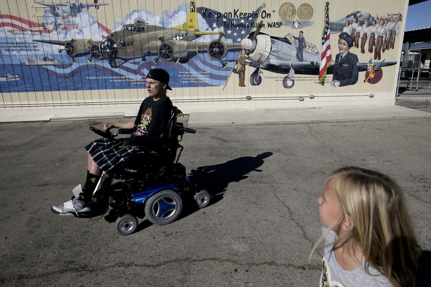 Jerral Hancock, a 27-year-old Iraq war veteran who lost his left arm and was paralyzed from the waist down in a bomb explosion, and his daughter, Anastasia, arrive at Lancaster High School for a meeting with members of Operation All The Way Home on Monday, Oct. 21, 2013, in Lancaster, Calif. (AP Photo/Jae C. Hong)