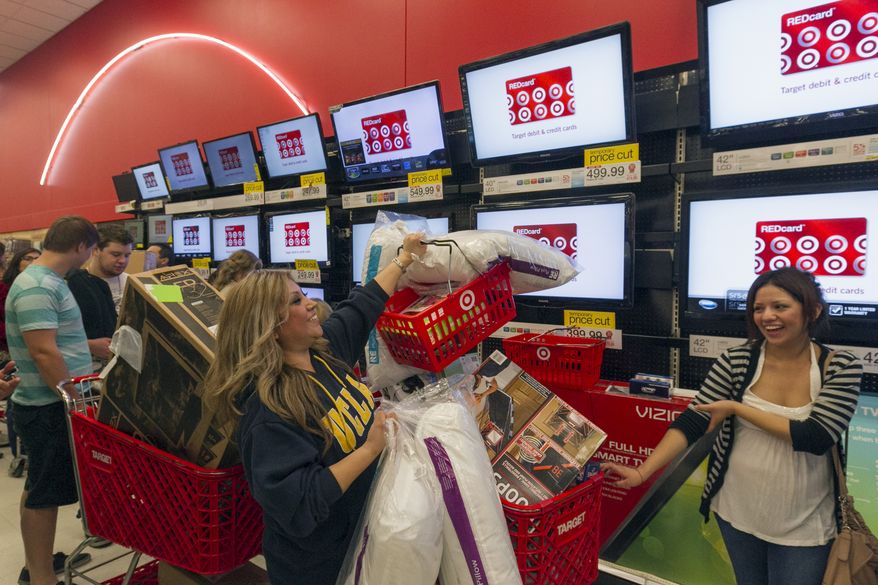 ** FILE ** Shopper Roxanna Garcia (middle) waits in line to pay for more than $1,000 in gifts at the Target store in Burbank, Calif., on Thursday, Nov. 22, 2012. (AP Photo/Damian Dovarganes)