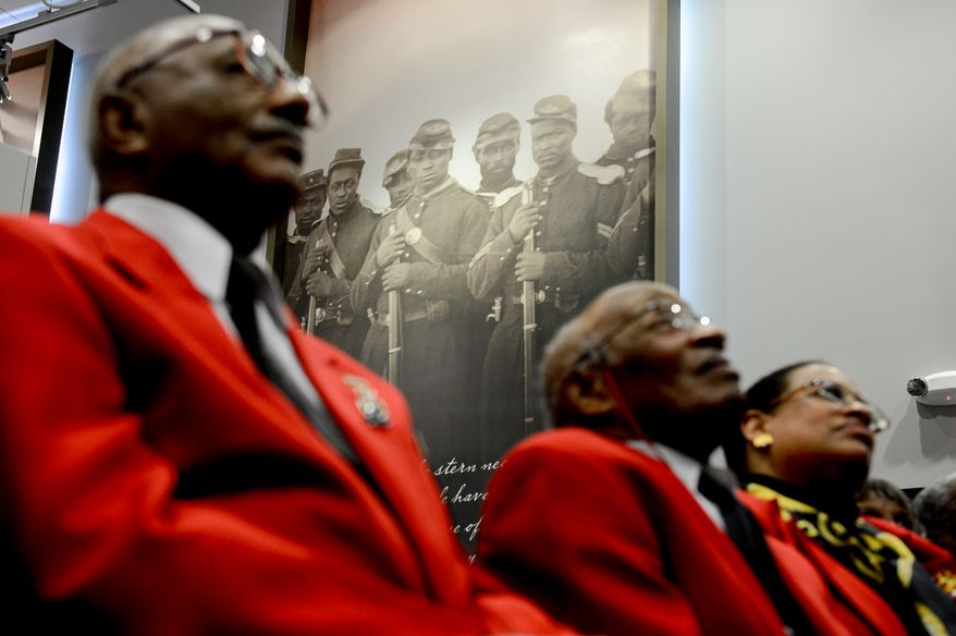 Members of the east coast chapter of the Tuskegee Airmen sit in front of large photographs of African American Civil War solders during a Veterans Day Wreath Laying and Commemoration at the African American Civil War Memorial Museum on Veterans Day, Washington, D.C., Monday, November 11, 2013. (Andrew Harnik/The Washington Times)