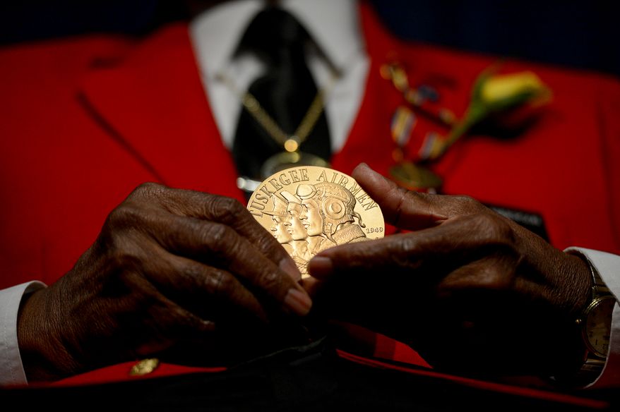Tuskegee Airman Major Louis Anderson Jr. holds up his Congressional Medal of Honor, presented to him by Rep. Eleanor Holmes-Norton (D-D.C.) during a Veterans Day Wreath Laying and Commemoration at the African American Civil War Museum on Veterans Day, Washington, D.C., Monday, November 11, 2013. (Andrew Harnik/The Washington Times)