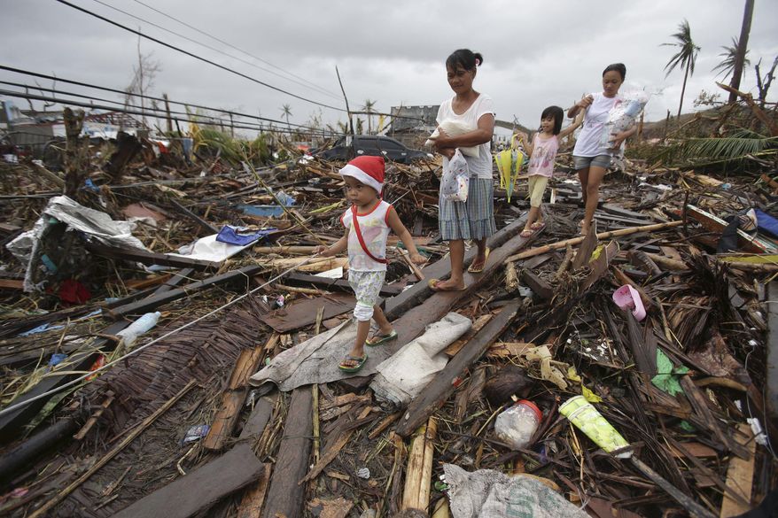Survivors walk in typhoon ravaged Tacloban city, Leyte province, central Philippines on Tuesday, Nov. 12, 2013. The Philippines emerged as a rising economic star in Asia but the trail of death and destruction left by Typhoon Haiyan has highlighted a key weakness: fragile infrastructure resulting from decades of neglect and corruption. (AP Photo/Aaron Favila)