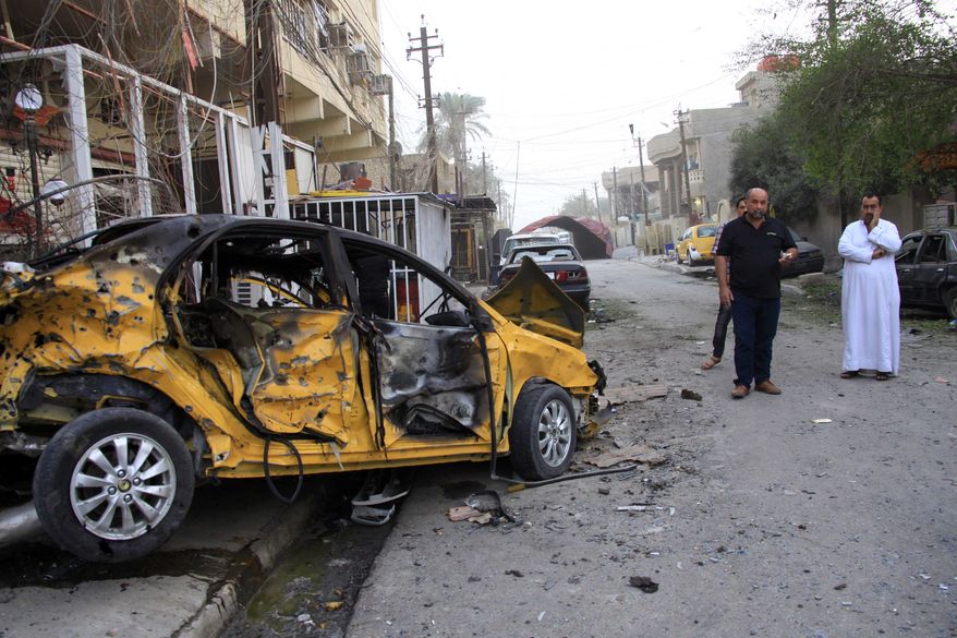 ** FILE ** On Saturday, Oct. 19, 2013, civilians inspect the aftermath of a Friday-night car bomb attack in Baghdad's eastern Mashtal neighborhood. (AP Photo/Hadi Mizban)
