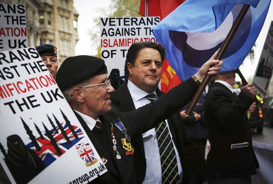 Nick Griffin, centre chairman of the far-right, British National Party joins members of the British Veterans' Group outside the Central Criminal Court the "Old Bailey" in London Monday Nov. 18, 2013, ahead of a court hearing of Michael Adebolajo, 28, and Michael Adebowale, 22, who are charged with the murder of British soldier Lee Rigby in May earlier this year. (AP Photo/Gareth Fuller/PA) UNITED KINGDOM OUT NO SALES NO ARCHIVE