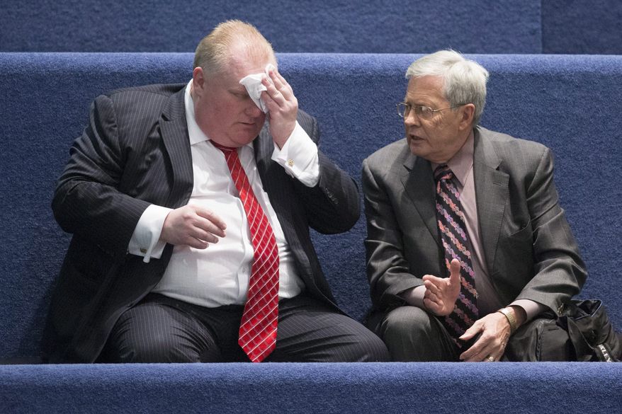 Toronto Mayor Rob Ford, left, sits with his lawyer George Rust-D'Eye in the council chamber as councillors look to pass motions to limit his powers at city hall in Toronto on Monday, Nov. 18, 2013. Blasting what he called a "coup d'etat," Ford said voters should be able to pass judgment on him, not his fellow councillors. (AP Photo/The Canadian Press, Chris Young)