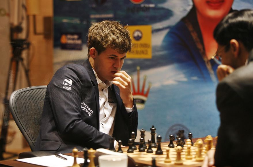 Norway's Magnus Carlsen, left, plays against reigning world chess champion India’s Viswanathan Anand during the Chess World Championship match in Chennai, India, Monday, Nov. 18, 2013. The 43- year old Anand has the advantage of playing at home in India, where he is treated as a super star. The 22-year-old Carlsen is the top Western player since Bobby Fischer in a game that has traditionally been dominated by Russians, and chess enthusiasts hope his mass-market appeal can win over new fans and help boost interest worldwide. (AP Photo/Arun Sankar K )