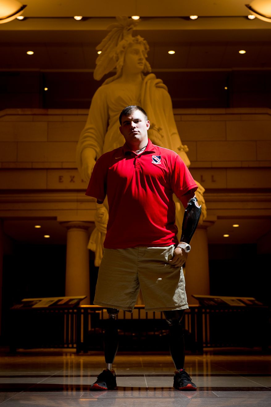 Quadruple amputee U.S. Army Staff Sergeant Travis Mills poses for a portrait before his documentary, "Travis: a Soldier's Story," about his life after being wounded, is screen in the Capitol Visitors Center at the U.S. Capitol Building, Washington, D.C., Monday, November 18, 2013. Mills is one of just five quadruple-amputees from the wars in Iraq and Afghanistan to survive their injuries. He was injured from an I.E.D. (improvised explosive device) on April 10, 2012 while on patrol during his third tour of duty in Afghanistan. (Andrew Harnik/The Washington Times)