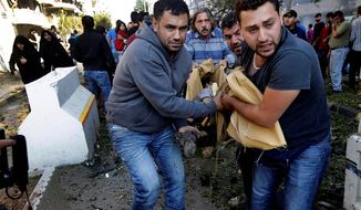 BLOODSHED: Lebanese men carry the body of a victim of explosions that struck near the Iranian Embassy in Beirut, in a stronghold of Hezbollah. (Associated Press)
