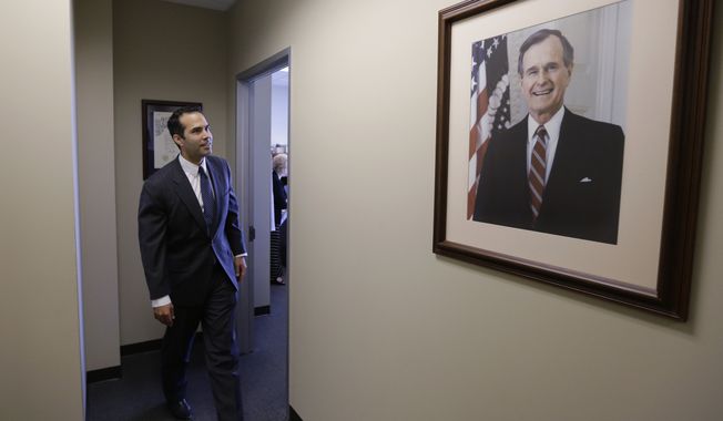 George P. Bush passes a portrait of his grandfather, George H.W. Bush, as visits the Republican Party of Texas headquarters where he formally filed to run for Texas land commissioner, Tuesday, Nov. 19, 2013, in Austin, Texas. Bush will face former El Paso Democratic Mayor John Cook in next November&amp;#8217;s election. (AP Photo/Eric Gay)