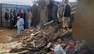 Muslim students stand in the rubble of an Islamic seminary that was hit by a suspected U.S. drone strike in Hangu district in Pakistan on Thursday. If confirmed, the missile strike outside of the northwest tribal areas would be a rarity. (Associated Press)