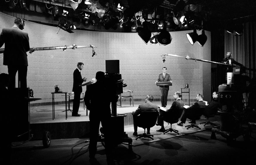 FILE - In this Oct. 21, 1960 file photo, Democratic presidential candidate, Sen. John F. Kennedy, center left, and Republican candidate, Vice President Richard Nixon, stand in a television studio during their presidential debate in New York. Polls found those who listened on radio awarded Nixon the debate victory. Those watching on TV gave Kennedy the nod. (AP Photo)