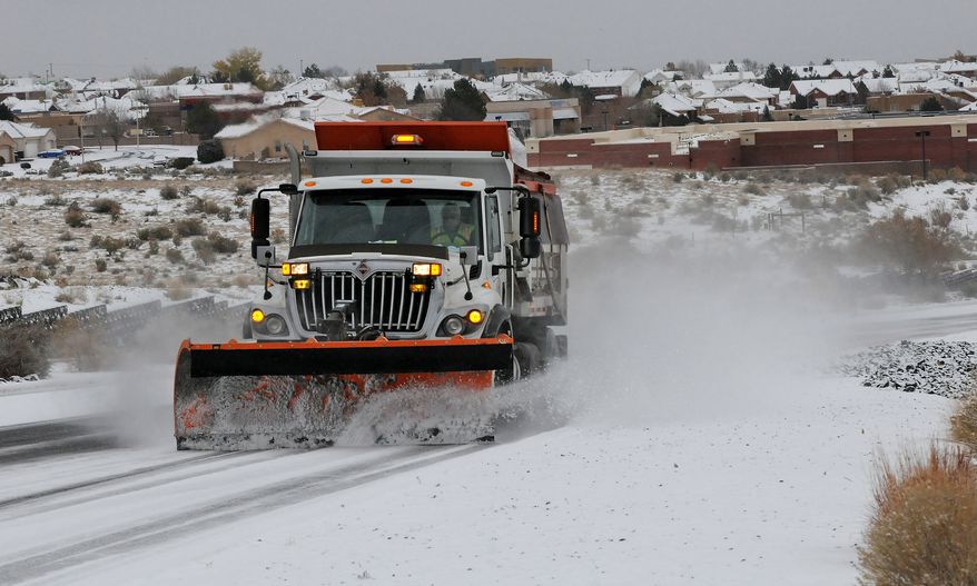 A Deptartment of Transportation plow and sanding truck heads up Paseo del Norte in Albuquerque, N.M., Sunday, Nov.24, 2013, in Albuquerque, N.M., after a winter storm hit New Mexico over the weekend making driving difficult. A large storm already blamed for at least eight deaths in the West slogged through Oklahoma, Texas, New Mexico and other parts of the southwest Sunday as it slowly churned east ahead of Thanksgiving. (AP Photos/Albuquerque Journal, Jim Thompson) THE SANTA FE NEW MEXICAN OUT