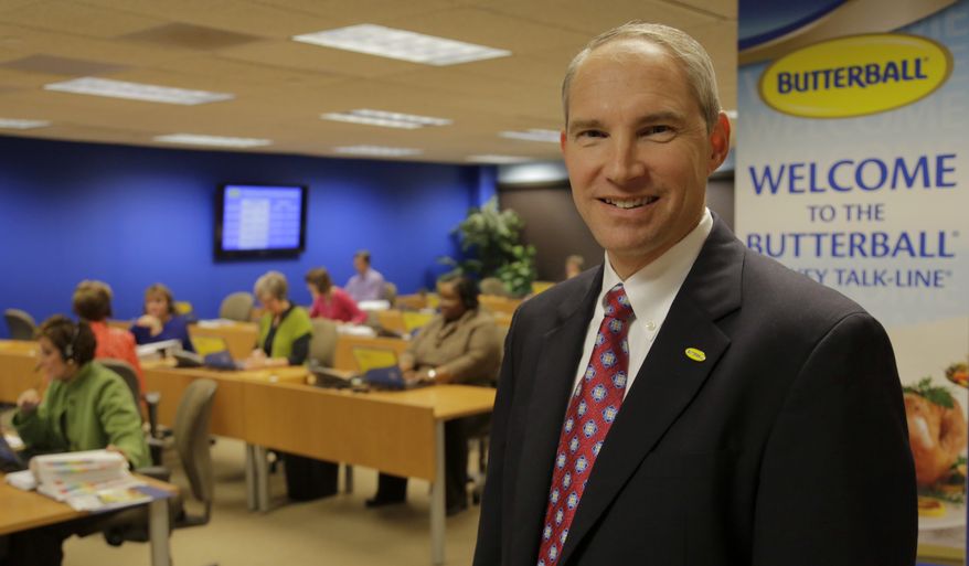 Butterball CEO Rod Brenneman stands in front of a group of Turkey Talk-Line experts at work in Naperville, Ill., on Friday, Nov. 22, 2013. (AP Photo/M. Spencer Green)