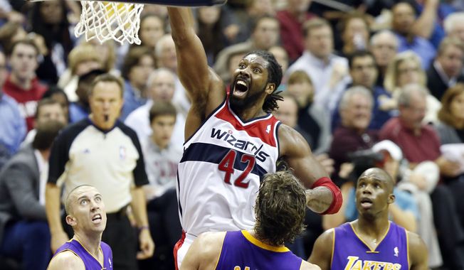 Washington Wizards forward Nene (42), from Brazil, shoots between Los Angeles Lakers guard Steve Blake (5), center Pau Gasol (16), from Spain, and guard Jodie Meeks (20) in the second half of an NBA basketball game Tuesday, Nov. 26, 2013, in Washington. Nene had 30 points and the Wizards won 116-111. (AP Photo/Alex Brandon)