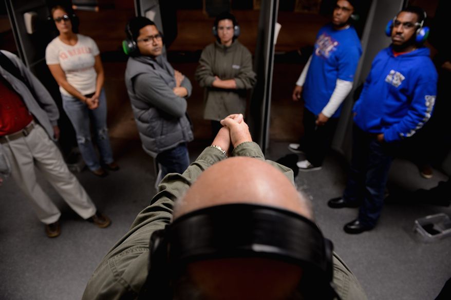 Participants in a handgun qualification license class listen to Dick Chiapparoli as he gives firing instructions during the live-shooting portion of the class at Gilbert's Indoor Shooting Range in Rockville. Maryland residents need to take the class before they can buy a gun under a law passed this year. (andrew harnik/the washington times)