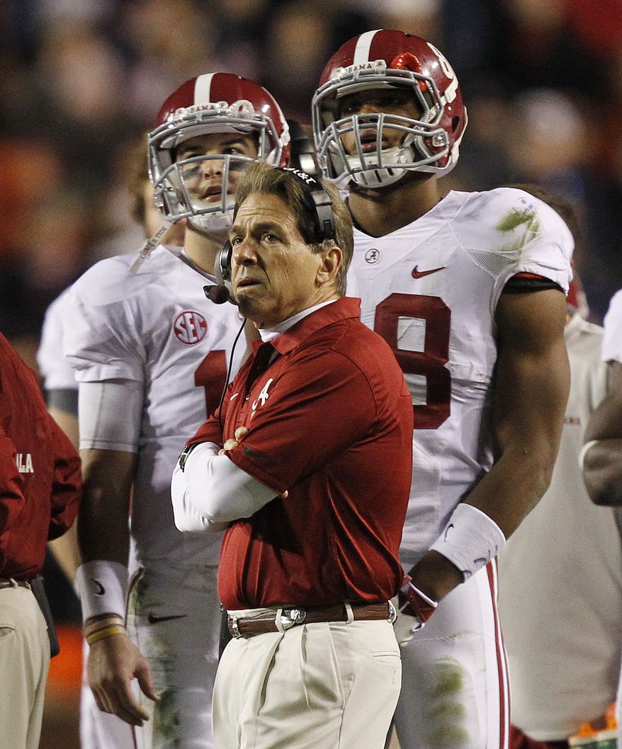 Alabama head coach Nick Saban watches the scoreboard along with quarterback AJ McCarron, left, and tight end Brandon Greene (89) during the second half of an NCAA college football game against Auburn in Auburn, Ala., Saturday, Nov. 30, 2013. Alabama appealed the final play and officials put 1 second on the clock. Alabama missed a field goal that Auburn returned 100-plus yards for the winning score. Auburn beat Alabama 34-28. (AP Photo/Butch Dill)