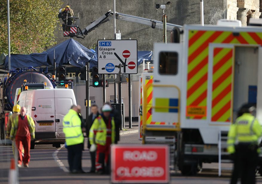 Police and Scottish Fire and Rescue services at the scene Saturday, Nov. 30, 2013, following the helicopter crash at the Clutha Bar in Glasgow, Scotland. Scottish emergency workers were sifting through wreckage Saturday for survivors of a police helicopter crash onto a crowded Glasgow pub that has killed at least one person and injured more than two dozen. The Clutha pub, near the banks of the River Clyde, was packed Friday night and a ska band was in full swing when the chopper slammed through the roof. The number of fatalities is expected to rise, officials said. (AP Photo/Scott Heppell)
