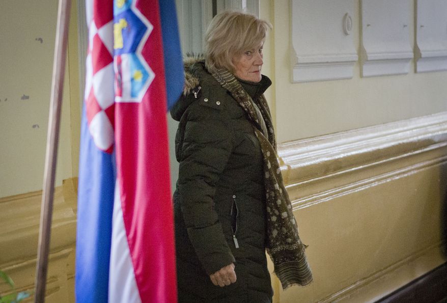 A voter walks past the Croatian flag at a polling station in Pula, Croatia, on Sunday, Dec. 1, 2013, as the nation votes in a referendum that could ban gay marriages. Conservative groups, backed by the Roman Catholic Church, demanded that the country's constitution define matrimony as a union of a man and a woman. The issue has divided the European Union's newest member nation. (AP Photo/Darko Bandic)