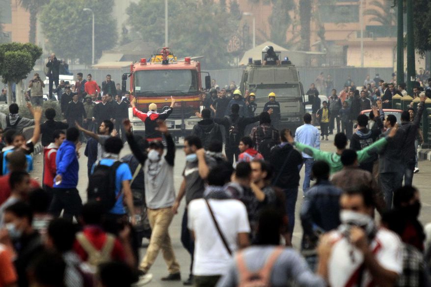 Egyptian security forces put up a roadblock to try to keep supporters of ousted Islamist President Mohammed Morsi away from Cairo's Tahrir Square on Sunday, Dec. 1, 2013. Police used heavy tear gas to clear hundreds of Morsi supporters from the central plaza shortly after they took it over. (AP Photo/El Shorouk, Ahmed Abd El Latif)
