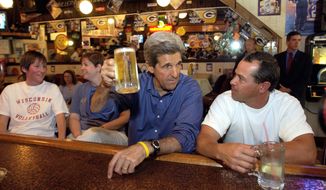 Democratic presidential nominee Sen. John Kerry, D-Mass, has a beer and watches the Green Bay Packers vs. the Indianapolis Colts football game on television during an unscheduled stop inside The Main Street Pub and Grill in Mount Horeb, Wis., Sunday, Sept. 26, 2004. To the right of Kerry is Dan DiMaggio, a patron. (AP Photo/Gerald Herbert)