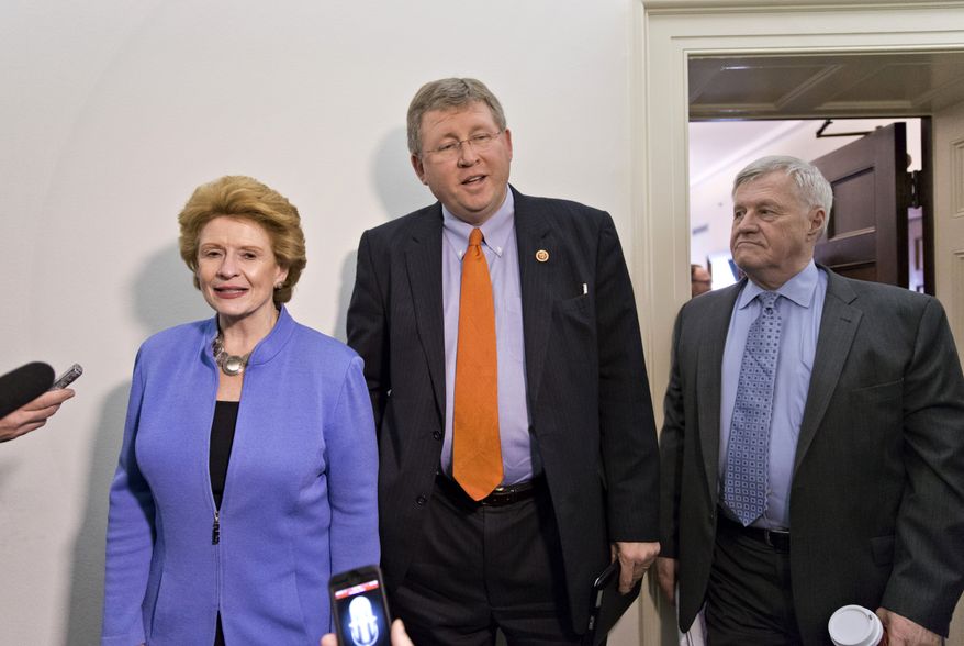 **FILE** Senate Agriculture Committee Chair Sen. Debbie Stabenow, D-Mich., left, and House Agriculture Committee Chairman Rep. Frank Lucas, R-Okla., right, are intercepted by reporters after negotigations on the Farm Bill wrapped up on Capitol Hill in Washington, Wednesday, Dec. 4, 2013. At far right is the House Agriculture Committee Ranking Democrat Rep. Collin Peterson, D-Minn. There is agreement on many parts of the legislation but significant differences remain over funding for the Supplemental Nutrition Assistance Program, more commonly known as food stamps. (Associated Press)