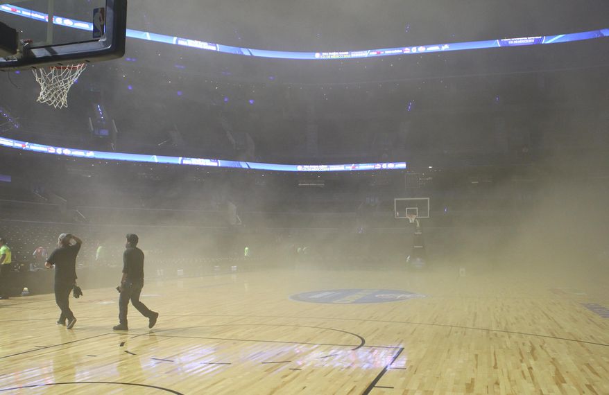 Smoke engulfs the court at The Mexico City arena in Mexico City, Wednesday, Dec. 4, 2013. The Mexico City arena where the San Antonio Spurs and Minnesota Timberwolves were playing an NBA game Wednesday night was evacuated 45 minutes before tip off because of smoke inside the arena. NBA spokeswoman Sharon Lima says the smoke was coming from a generator fire outside the arena. (AP Photo/Christian Palma)