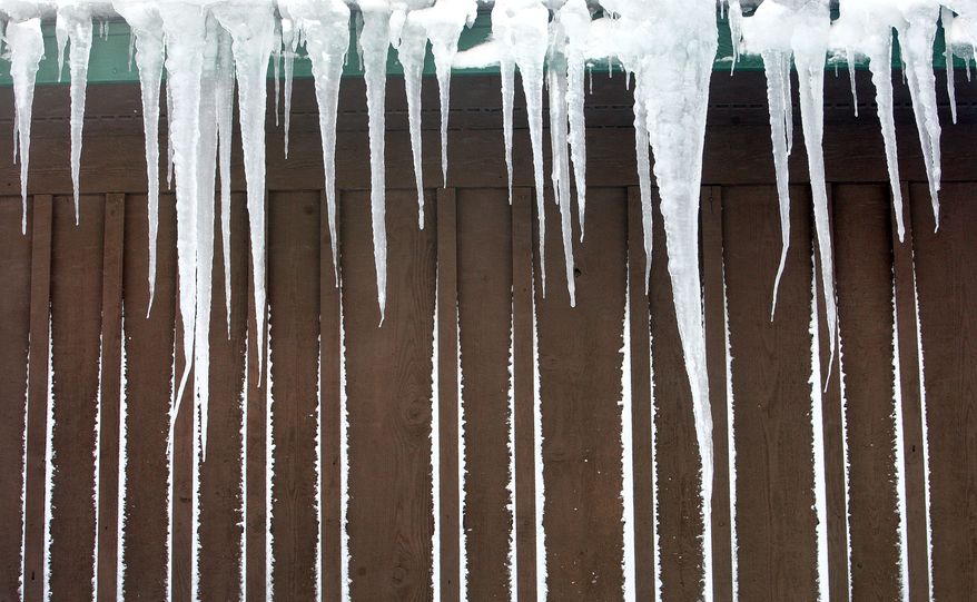 Icicles hang from the roof of Stokkes Lakewood Market in Lakewood Township Thursday, Dec. 5, 2013 after temperatures fell into the single digits overnight. Snow from the storm's strong winds still sticks to the outside wall. (AP Photo/Duluth News Tribune, Bob King)