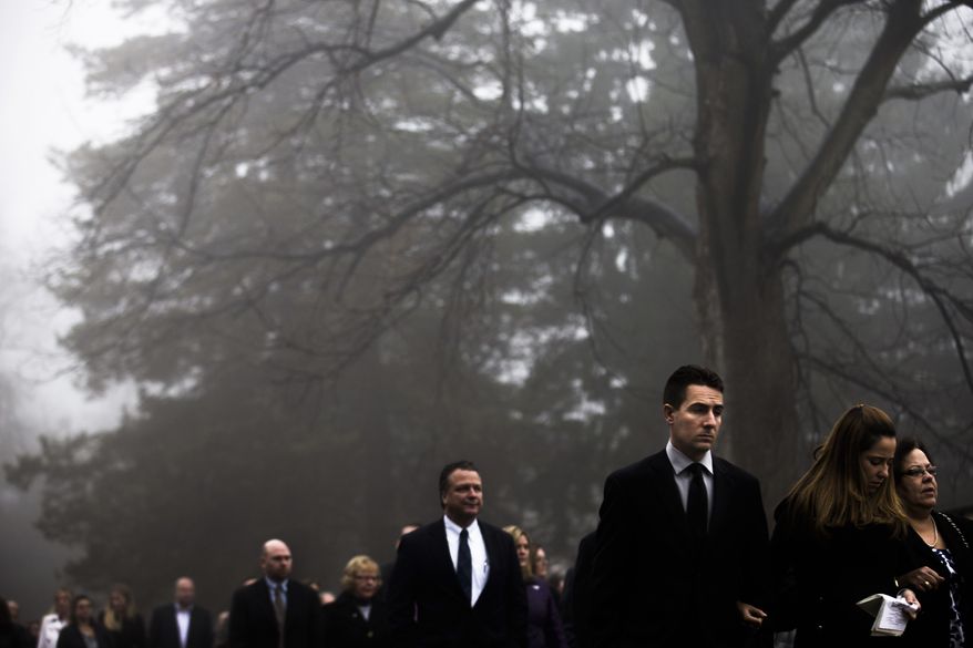Mourners follow a hearse carrying the casket of James Ferrari from the Church of the Divine Love towards his grave plot, Thursday, Dec. 5, 2013, in Montrose, N.Y. Ferrari, 59, was killed along with three others when a speeding Metro-North Railroad train on the Hudson Line derailed in New York City. (AP Photo/John Minchillo)