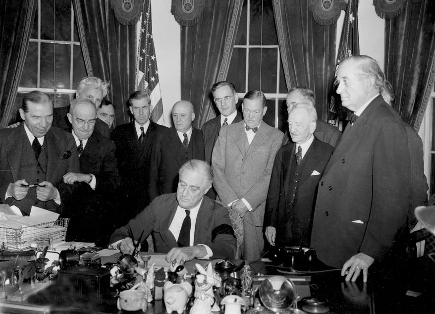 In this file photo, U.S. President Franklin D. Roosevelt signs the declaration of war following the Japanese bombing of Pearl Harbor, Dec. 7, at the White House in Washington, D.C., Dec. 8, 1941 at 3:08 p.m. EST. Watching from left to right are, Rep. Sol Bloom, D-N.Y.; Rep. Luther Johnson, D-Texas; Rep. Charles A. Eaton, R-N.J.; Rep. Joseph Martin, R-Mass.; Vice President Henry A. Wallace; House Speaker Sam Rayburn, D-Texas; Rep. John McCormack, D-Mass.; Sen. Charles L. McNary, R-Ore.; Sen. Alben W. Barkley, D-Ky.; Sen. Carter Glass, D-Va.; and Sen. Tom Connally, D-Texas. (AP Photo, file)