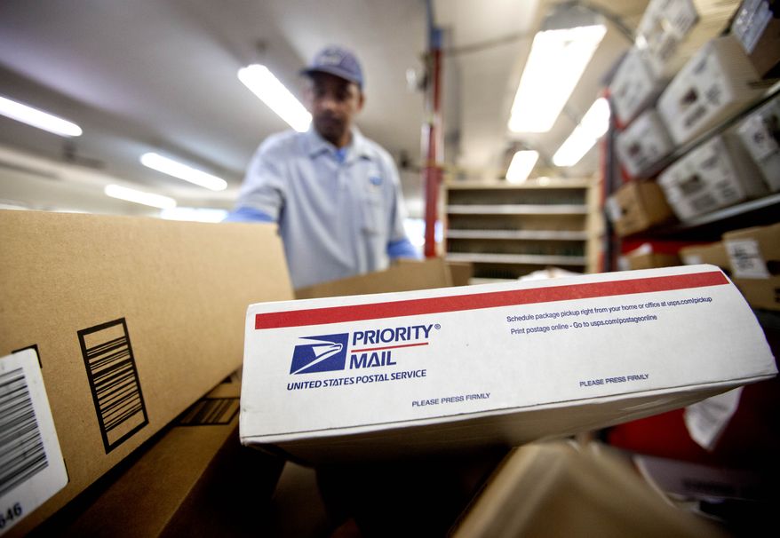**FILE** Packages wait to be sorted in a Post Office in Atlanta on Feb. 7, 2013, as U.S. Postal Service carrier Michael McDonald gathers mail to load into his truck before making his delivery run. (Associated Press)