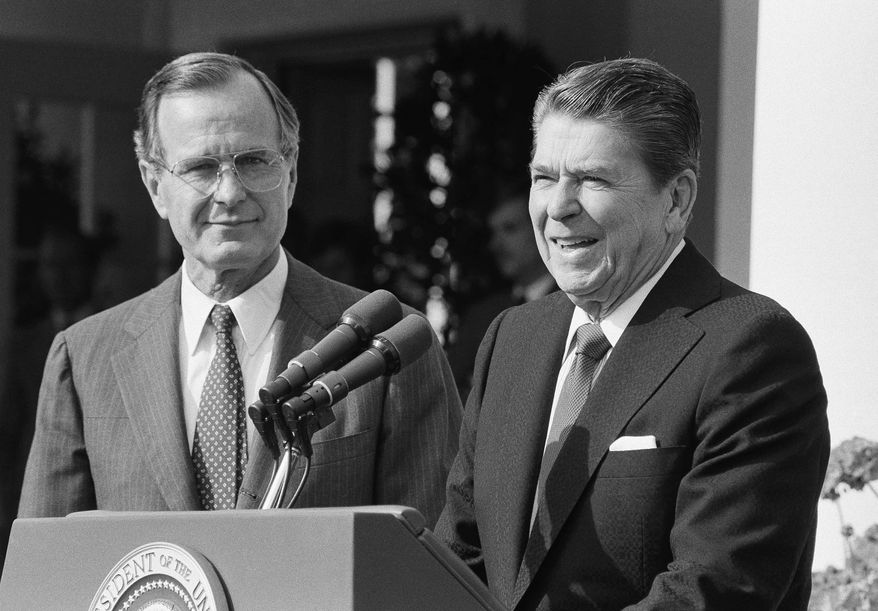 President Ronald Reagan and Vice President George H.W. Bush meet with members of the U.S. Committee on Pacific Economic Cooperation on Tuesday, Sept. 18, 1984 in the White House Rose Garden in Washington. (AP Photo/Barry Thumma)