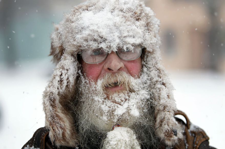 Randy Friedrich of Springfield, Ore. sports a coating of fresh snow as he visits downtown Springfield, Ore. Friday, Dec. 6, 2013. Friedrich, originally from Wisconsin, said he was enjoying the snow day as a storm moves through the Willamette Valley in Oregon (AP Photo/The Register-Guard, Chris Pietsch)
