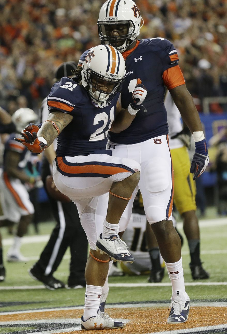 Auburn running back Tre Mason (21) celebrates bios touchdown against Missouri during the second half of the Southeastern Conference NCAA football championship game, Saturday, Dec. 7, 2013, in Atlanta. (AP Photo/Dave Martin)